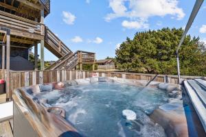a hot tub in a backyard with a wooden fence at 7015 - Nirvana by Resort Realty in Rodanthe