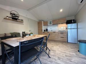 a kitchen with a table and chairs and a refrigerator at MOBIL HOME saint Raphael camping l’île d’or in Saint-Raphaël
