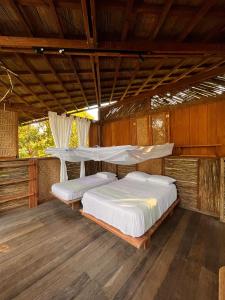 1 dormitorio con 2 camas en una habitación de madera en luzzul, en Nuquí