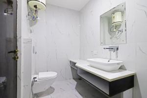 a white bathroom with a sink and a toilet at Dilli Airport Stay Hotel Near Delhi Airport in New Delhi