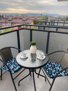 a table with two chairs and a vase on a balcony at Apartament Browarna in Nowy Sącz