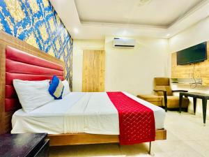 Schlafzimmer mit einem Bett mit einer roten und weißen Decke in der Unterkunft Glacee Stay Hotel Near Delhi Airport in Neu-Delhi
