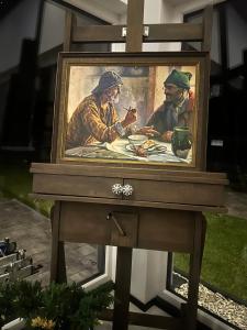 una pintura de dos hombres sentados en una mesa en Marina Resort Chłopy en Chłopy