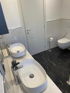 een badkamer met een witte wastafel en een toilet bij Appartamento "Da Maddalena" in Menaggio