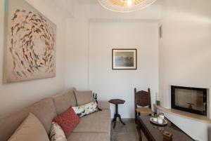a living room with a couch and a tv at aerie home Skyros in Skiros