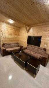 a living room with two couches and a flat screen tv at The Lodge Ajloun in Ajloun
