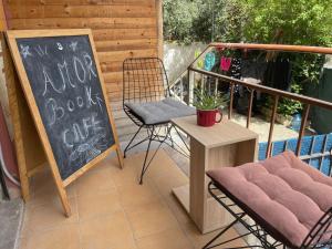 a patio with a table and a chair and a chalkboard at Amor_Bookstore in Durrës