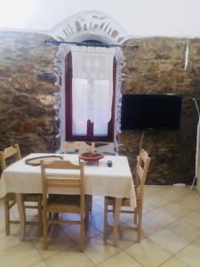 a table and chairs in a room with a tv at Mastic castle house in Mestá
