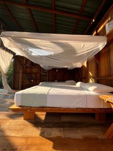 a bed with a canopy on a wooden platform at luzzul in Nuquí