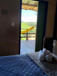 a bedroom with a bed with towels on it at Cafezal em Flor Turismo e Cafés Especiais in Monte Alegre do Sul