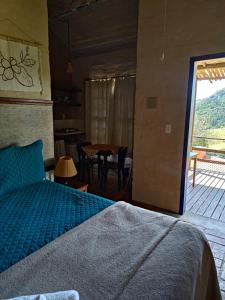 1 dormitorio con 1 cama y comedor con mesa en Cafezal em Flor Turismo e Cafés Especiais, en Monte Alegre do Sul