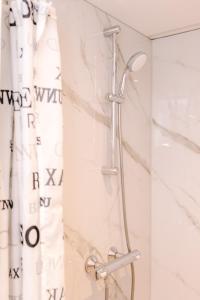 eine Dusche im Bad mit Duschvorhang in der Unterkunft Studio Maxime in Zandvoort