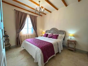 une chambre avec un grand lit avec des draps violets dans l'établissement Tenuta Fiumara, à Marina di Grosseto