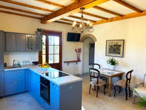 una cucina con armadi blu e tavolo con sedie di Tenuta Fiumara a Marina di Grosseto