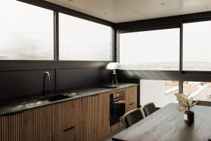 a kitchen with a table with chairs and windows at L'Empreinte in Verzenay