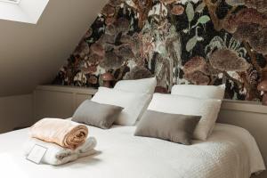 a bedroom with two white beds with a wall mural at L'Empreinte in Verzenay