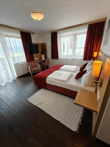Hotel Restaurant Perschler في Rattenberg: غرفة نوم بسرير كبير مع بطانية حمراء