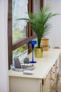 a table with a plant and a blue vase on it at Emili Apartman Ráckeve in Ráckeve