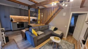 un salon avec un canapé et une cuisine dans l'établissement Căsuța din povești, à Reci