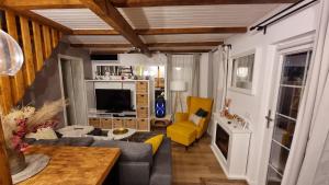 un salon avec un canapé et une télévision dans l'établissement Căsuța din povești, à Reci