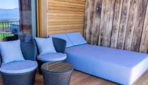 a bench and two chairs on a porch at Hotel Restaurant Perschler in Rattenberg