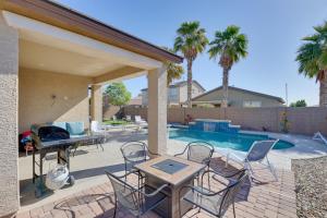 un patio con sillas, una mesa y una piscina en 3 Mi to Goodyear Ballpark Desert Den with Pool, en Goodyear