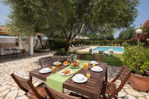 Almiros BeachにあるSkales Villasのプール付きの庭にテーブルと食べ物
