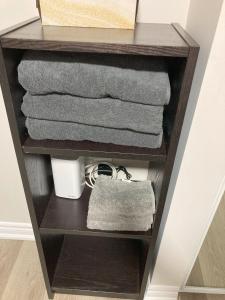 a shelf with towels and a pile of towels at Brand New, cozy 2 Bdrm Bsmnt Apt in Mississauga