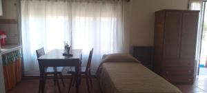 1 dormitorio con cama, mesa y ventana en La Luisa en Embalse