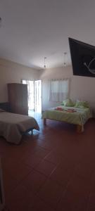 1 dormitorio con 2 camas y TV en la pared en La Luisa en Embalse