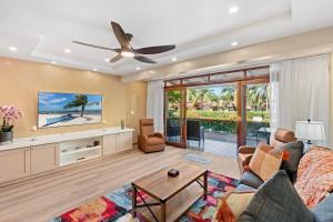 プラヤ・フラミンゴにあるStylish 2-Bedroom Beach Condo with Ocean-View Deck, Lush Pool Area & 2-Minute Walk to Flamingo Beachのソファと天井ファンのあるリビングルーム