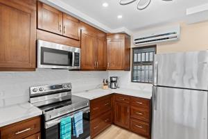 プラヤ・フラミンゴにあるStylish 2-Bedroom Beach Condo with Ocean-View Deck, Lush Pool Area & 2-Minute Walk to Flamingo Beachのキッチン(木製キャビネット、ステンレス製の電化製品付)
