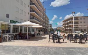an outdoor patio with tables and chairs and an umbrella at Bellreguard Playa 5 in Bellreguart