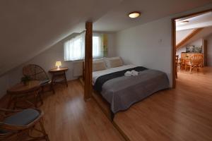 a bedroom with a bed and a table and chairs at Apartmany ZEA in Tatranská Lomnica
