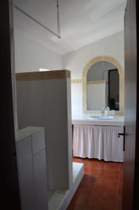 a white bathroom with a sink and a mirror at Sunday every Day in Olho Marinho