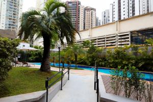 uma palmeira ao lado de uma piscina numa cidade em Intercity São Paulo Ibirapuera em São Paulo