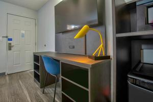a desk with a yellow lamp and a blue chair at Motel 6-Richland, WA - Kennewick in Richland