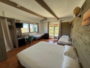 a bedroom with two beds and a desk at Mas Des Salicornes in Saintes-Maries-de-la-Mer