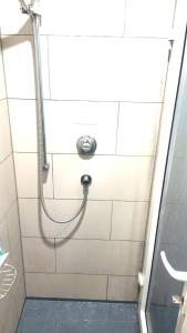 een douche met een slang in de badkamer bij Luxurious Soft Water Air Conditioning TV BITCOIN in Londen
