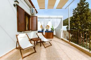 balkon z dwoma krzesłami i stołem w obiekcie Erotokritos Deluxe Suite With Jacuzzi w mieście Perivólia