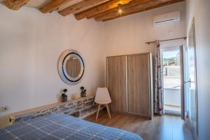 Schlafzimmer mit einem Bett und einem Wandspiegel in der Unterkunft A window to the Aegean in Kokkari