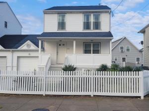 a white fence in front of a white house at North Beach Retreat in Atlantic City