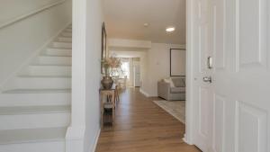 a hallway of a home with a staircase and a living room at North Beach Retreat in Atlantic City