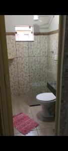 a bathroom with a toilet and a glass shower at Hospedagem De Ferias in Bonito