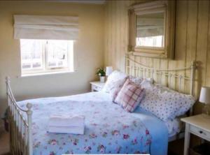 a bedroom with a bed and two windows at Beech cottage ~ close to York ~ cozy rural stay in Stamford Bridge