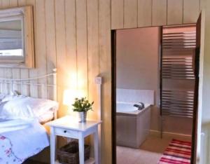 - une chambre avec un lit, une baignoire et un lavabo dans l'établissement Beech cottage ~ close to York ~ cozy rural stay, à Stamford Bridge
