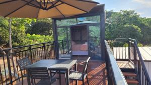eine Terrasse mit einem Tisch, Stühlen und einem Sonnenschirm in der Unterkunft Suíte, casal - 2, área exclusiva in Cavalcante