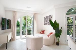 Elle comprend un salon doté d'un mobilier blanc et de grandes fenêtres. dans l'établissement VILLA DES PERGOLAS au pied du TRAM ,à 5 min des plages , 15 min du Centre , jacuzzi, à Nice