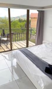 a bedroom with a bed and a view of a deck at The Lodge Ajloun in Ajloun