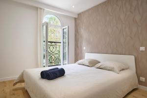 une chambre avec un grand lit blanc avec une fenêtre dans l'établissement VILLA DES PERGOLAS au pied du TRAM ,à 5 min des plages , 15 min du Centre , jacuzzi, à Nice